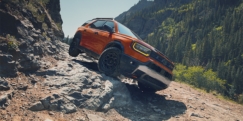 Orange off-road truck climbing rocky terrain
